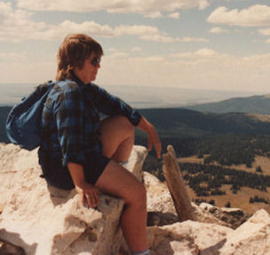 Karen sitting on a rock overlooking a Colorado valley